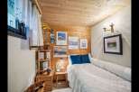 Cozy bedroom with wooden paneling and a comfortable bed.