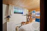This cozy bedroom features a warm wooden ceiling and walls, creating a rustic and inviting atmosphere.