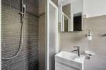 This modern bathroom features a sleek shower with a glass door and stylish tile work.
