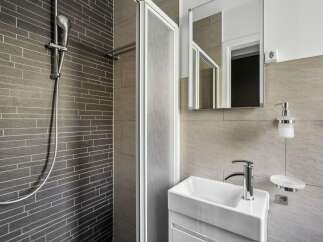 This modern bathroom features a sleek shower with a glass door and stylish tile work.