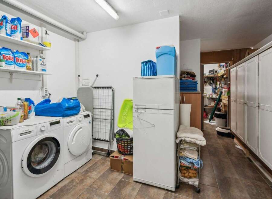This laundry room offers a practical and organized space for all your washing needs.