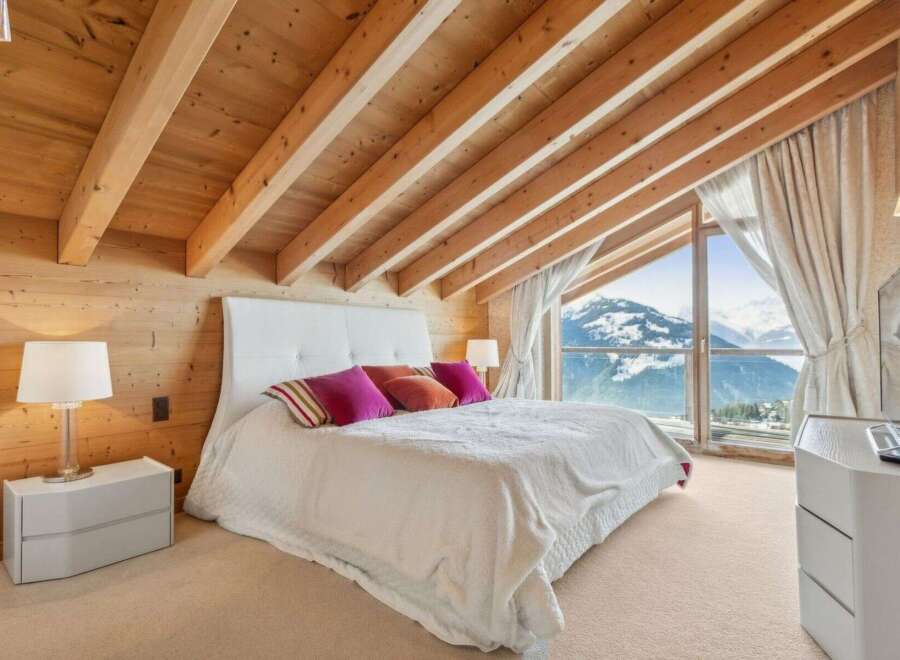 Experience luxury living in this stunning bedroom with breathtaking mountain views.