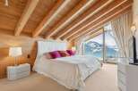 Experience luxury living in this stunning bedroom with breathtaking mountain views.