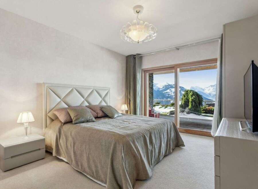 Experience luxury living in this stunning bedroom with breathtaking mountain views.