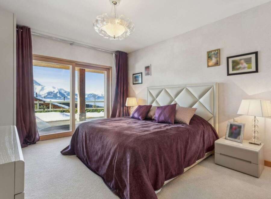 Experience luxury living in this stunning bedroom with breathtaking mountain views.