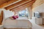 Experience luxury living in this stunning bedroom with breathtaking mountain views.