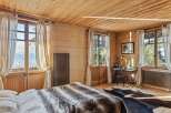 Experience the warmth of this charming bedroom, featuring stunning wooden walls and ceilings that create a cozy atmosphere.