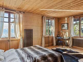 Experience the warmth of this charming bedroom, featuring stunning wooden walls and ceilings that create a cozy atmosphere.