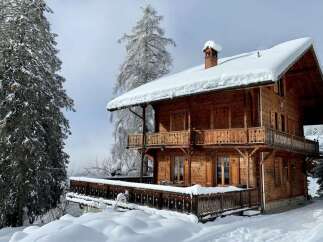 Experience the charm of this stunning wooden chalet nestled in a snowy wonderland.