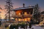 Experience the charm of this rustic wooden chalet, nestled amidst a serene winter landscape.
