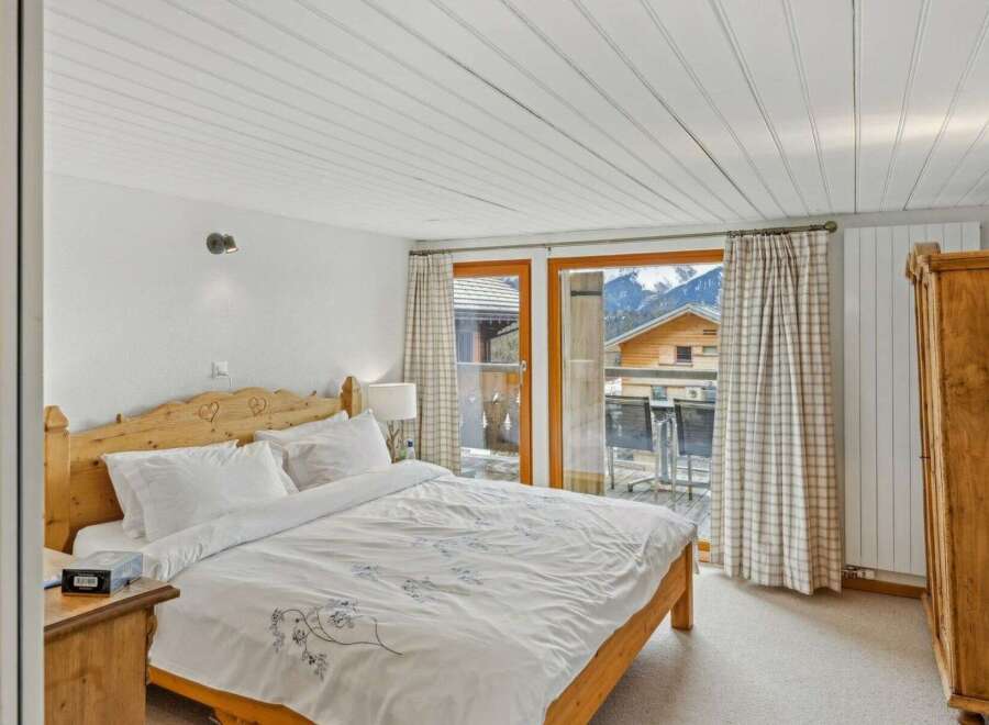 This charming bedroom offers a cozy retreat with a stunning mountain view.
