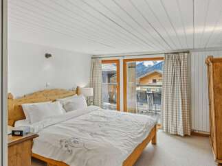 This charming bedroom offers a cozy retreat with a stunning mountain view.