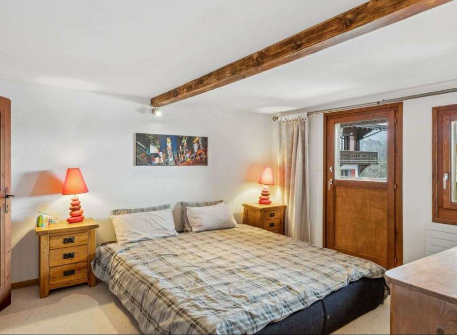 This cozy bedroom features a comfortable bed with a plaid comforter, perfect for a relaxing night's sleep.