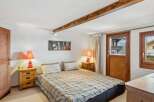 This cozy bedroom features a comfortable bed with a plaid comforter, perfect for a relaxing night's sleep.
