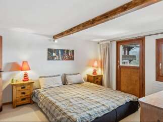 This cozy bedroom features a comfortable bed with a plaid comforter, perfect for a relaxing night's sleep.