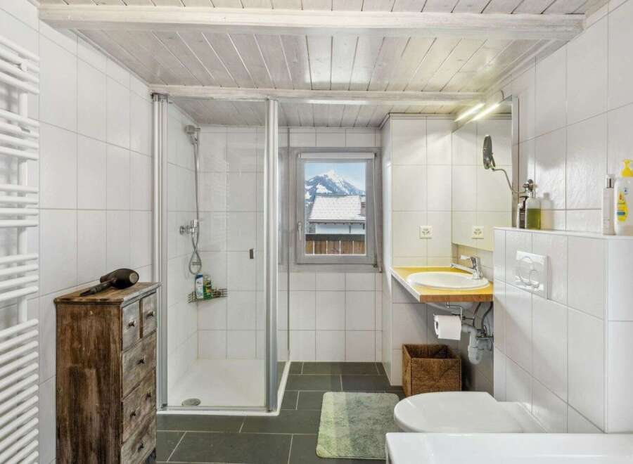 Discover the charm of this bathroom, featuring a sleek glass shower and a stylish wooden vanity.