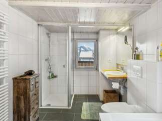 Discover the charm of this bathroom, featuring a sleek glass shower and a stylish wooden vanity.