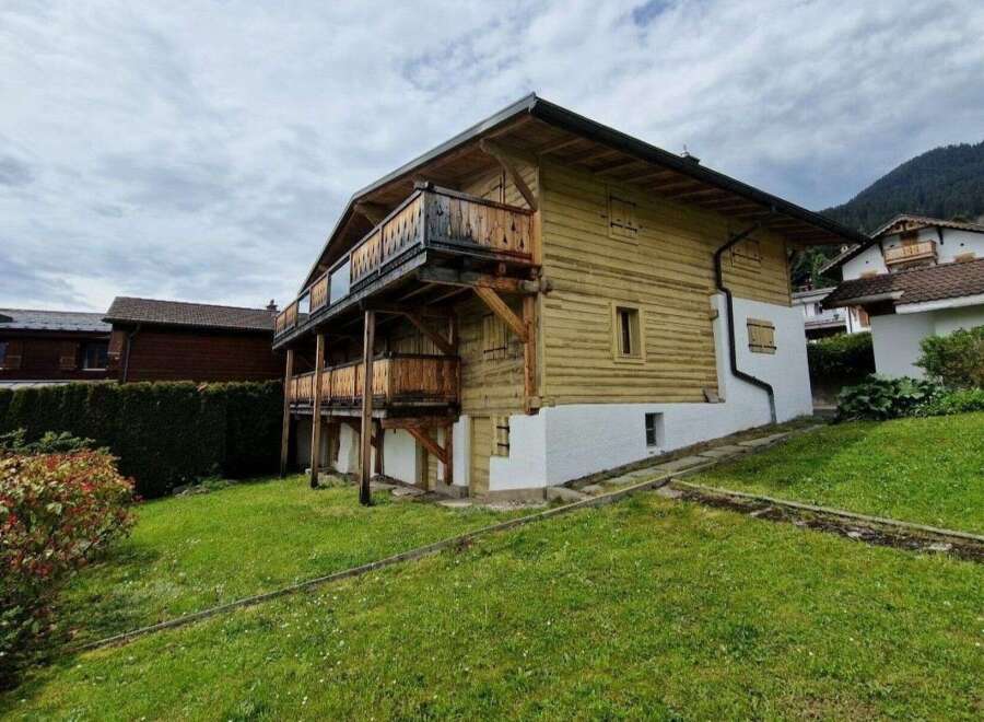 Discover this charming chalet-style home, boasting a classic wooden facade and inviting balconies.
