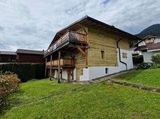 Discover this charming chalet-style home, boasting a classic wooden facade and inviting balconies.