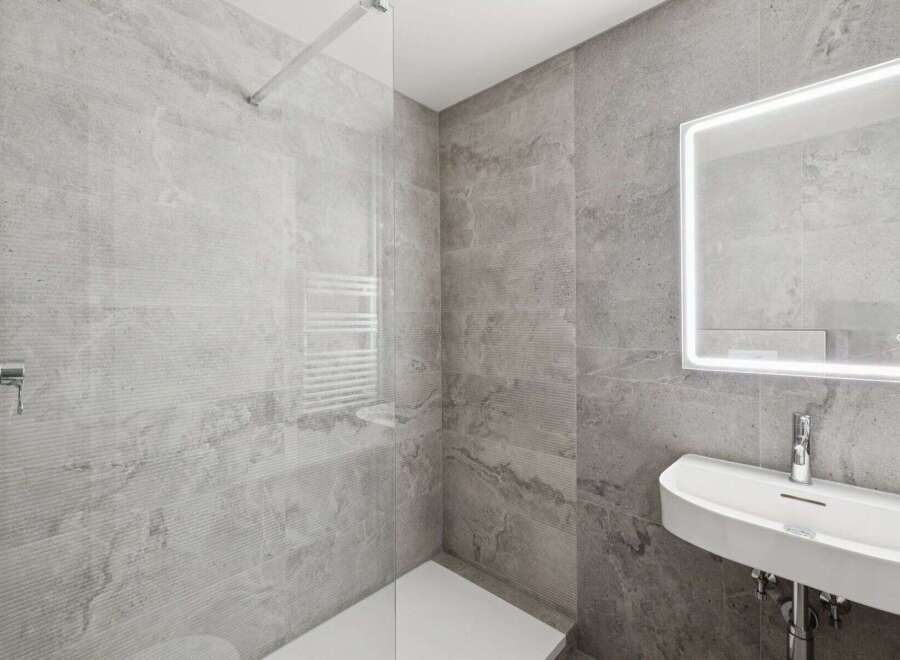 Step into a modern bathroom oasis, featuring sleek gray tiles and a minimalist design.