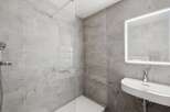 Step into a modern bathroom oasis, featuring sleek gray tiles and a minimalist design.