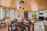 Experience elegant dining in this beautifully appointed room, featuring a rich wooden dining table set for a feast and surrounded by comfortable chairs.