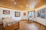 Experience cozy mountain living in this charming bedroom featuring a warm wooden ceiling and floors.