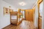 This charming bedroom features a cozy wooden bunk bed, perfect for families or guests.