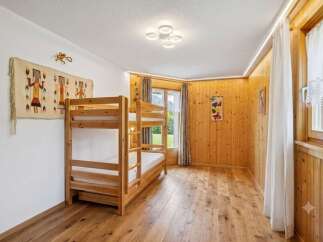 This charming bedroom features a cozy wooden bunk bed, perfect for families or guests.