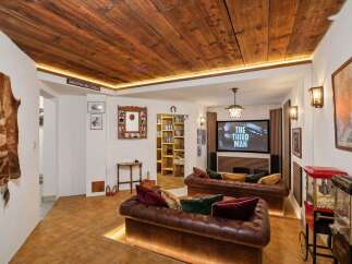 Experience cinematic entertainment in this unique basement media room, featuring plush leather sofas and a large screen perfect for movie nights.