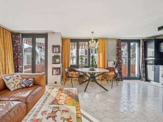 Discover this stunning property featuring a stylish living room with a comfortable leather sofa and vibrant decor.