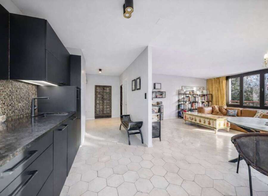 Discover modern living in this stylish property, featuring a sleek kitchen with dark cabinetry and a mosaic backsplash.