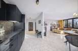 Discover modern living in this stylish property, featuring a sleek kitchen with dark cabinetry and a mosaic backsplash.
