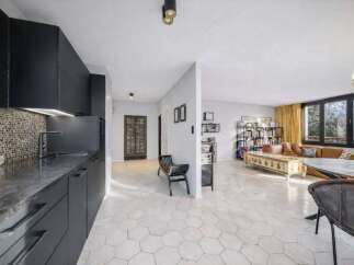 Discover modern living in this stylish property, featuring a sleek kitchen with dark cabinetry and a mosaic backsplash.