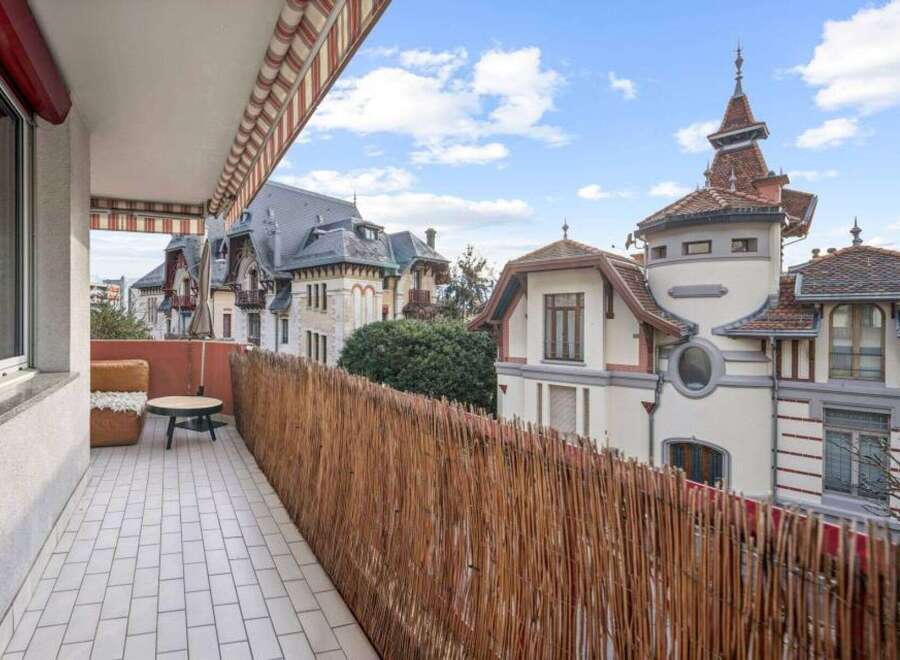 Enjoy stunning views from this charming balcony! This property features a cozy seating area and a unique woven fence, creating a private and inviting outdoor space.