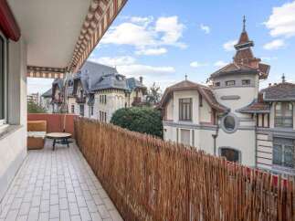 Enjoy stunning views from this charming balcony! This property features a cozy seating area and a unique woven fence, creating a private and inviting outdoor space.