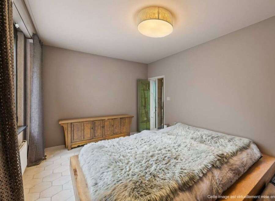 Discover the charm of this inviting bedroom, featuring a cozy bed adorned with a plush, textured blanket.