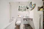 Step into this unique bathroom featuring artistic mirrors and a modern sink.