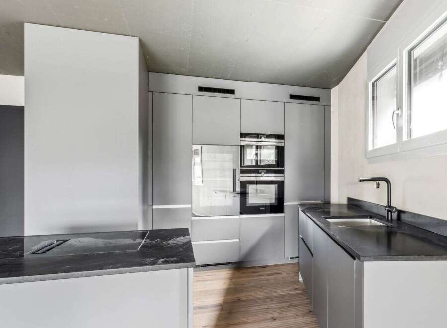 This modern kitchen boasts sleek, minimalist design with high-end appliances and ample storage.