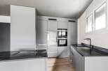 This modern kitchen boasts sleek, minimalist design with high-end appliances and ample storage.