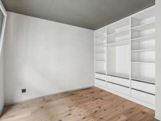 Discover the elegance of this modern space, featuring a custom-built white closet system offering ample storage.