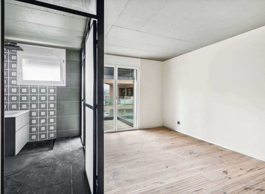 Discover modern living in this stylish property, featuring a sleek bathroom with contemporary tiling and a bright, airy living space.
