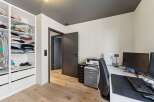 This modern home office features a sleek design with a built-in closet for ample storage.