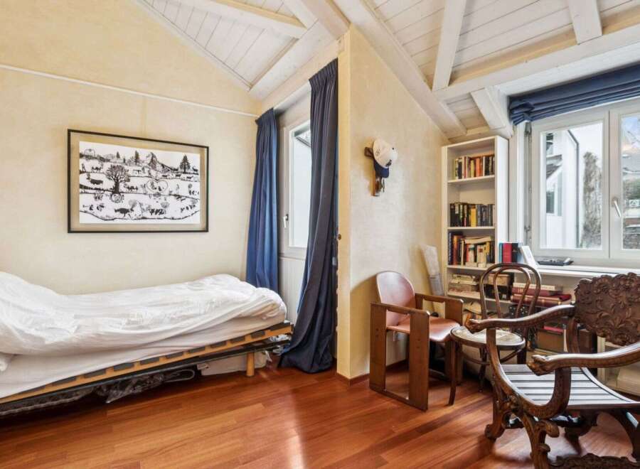 Discover the charm of this cozy bedroom, featuring a unique sloped ceiling and exposed beams that add character.