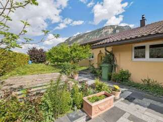 Discover the charm of this beautiful property, featuring a well-maintained garden and a stunning mountain backdrop.