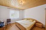 This cozy bedroom features a warm wooden ceiling and flooring, creating a welcoming atmosphere.