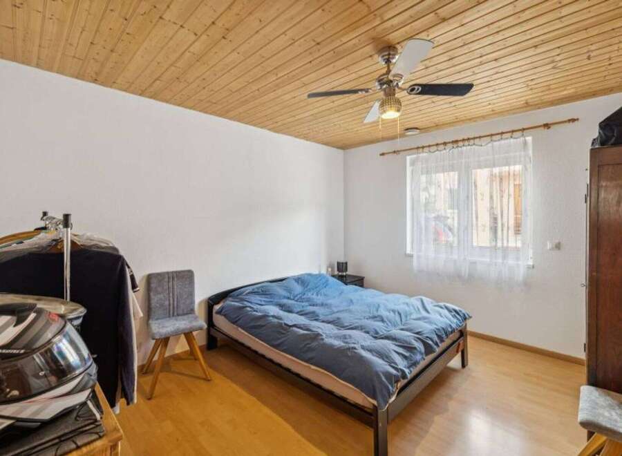 This cozy bedroom features a comfortable bed with a blue comforter, perfect for a relaxing night's sleep.