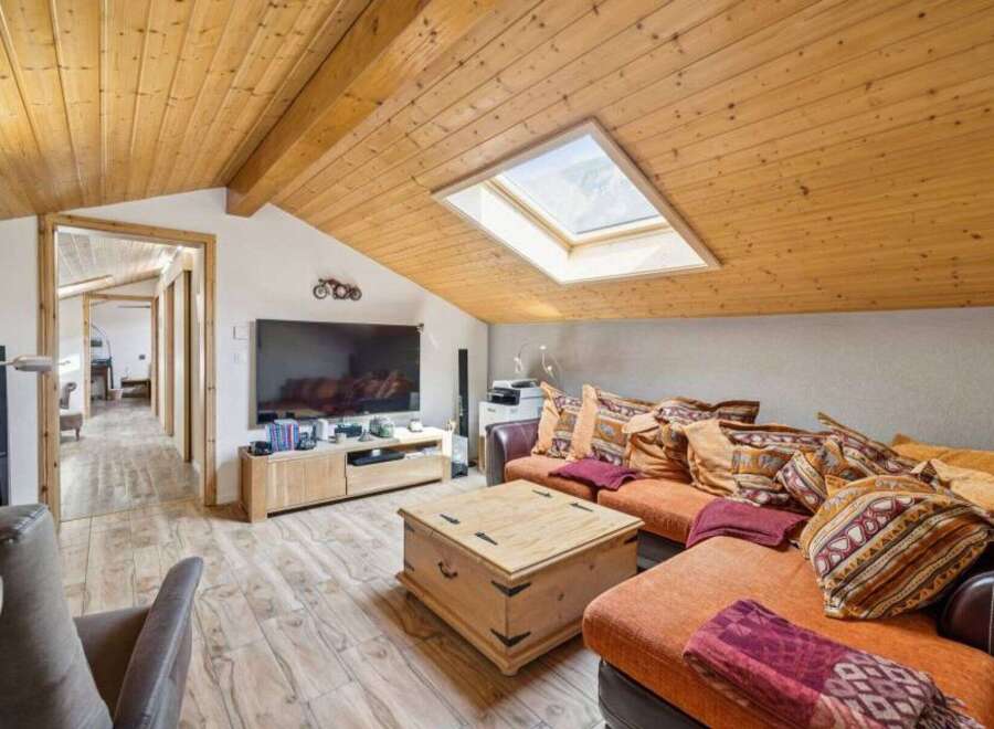 Discover the charm of this stunning property, featuring a cozy living room with a unique sloped ceiling and a skylight that floods the space with natural light.
