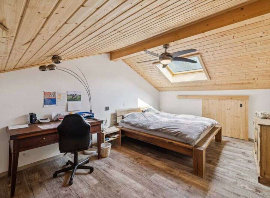 Discover the charm of this inviting bedroom, featuring a unique sloped ceiling and a skylight that floods the space with natural light.