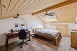 Discover the charm of this inviting bedroom, featuring a unique sloped ceiling and a skylight that floods the space with natural light.